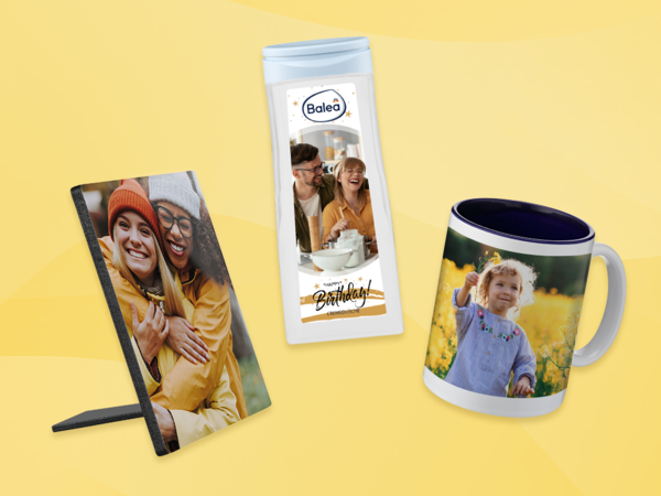 Fotogeschenke mit persönlichen Bildern: Tischaufsteller, Duschgel mit Etikett und Fototasse auf gelbem Hintergrund.