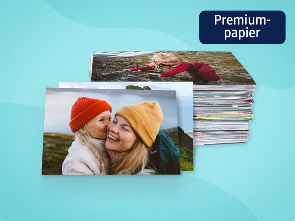 Zwei Fotoabzüge mit Bildern von Mutter und Tochter sind angelehnt an einen Stapel voller Fotoabzüge.